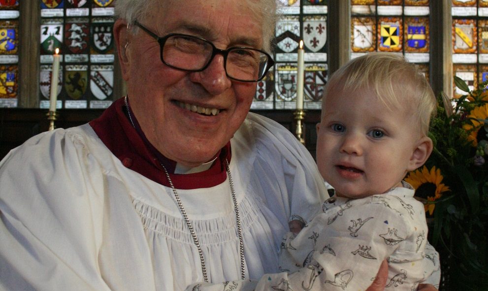 A Bishop and proud grandfather baptises his grandson