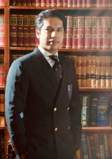 photo of Muhammad Ahmad Pansota in front of library bookcase