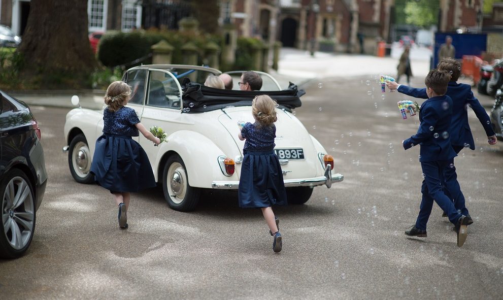 Children chasing after a wedding car at Lincoln's Inn